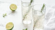 Two glasses of water mixed with chia seeds and sprigs of rosemary