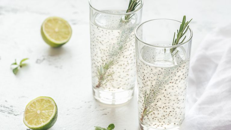 Two glasses of water mixed with chia seeds and sprigs of rosemary