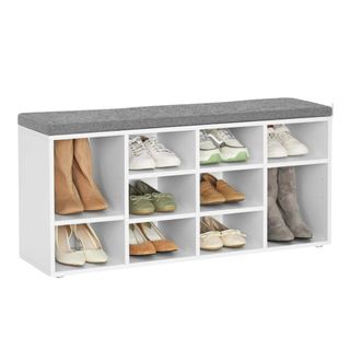 A white shoe storage bench with a gray top and shoes in it