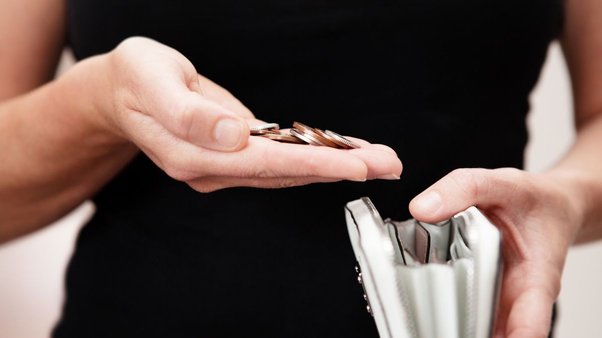 Woman with coins in hand with purse