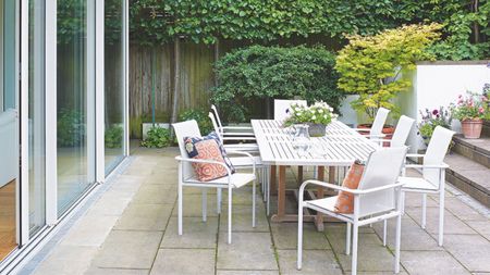Paved patio with white table and chairs