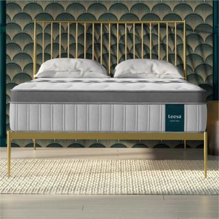 Leesa Legend Chill Hybrid Mattress on a gold frame against a blue and gold wall. 