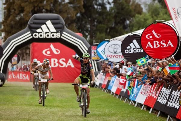 Mixed category race leader Barti Bucher carries his bike across a river