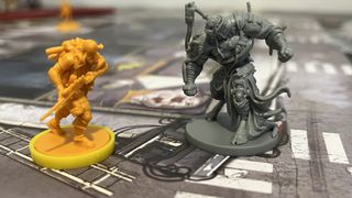 Survivor and abomination mini standing on a game tile from Zombicide