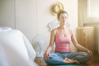 A woman meditating in her bedroom