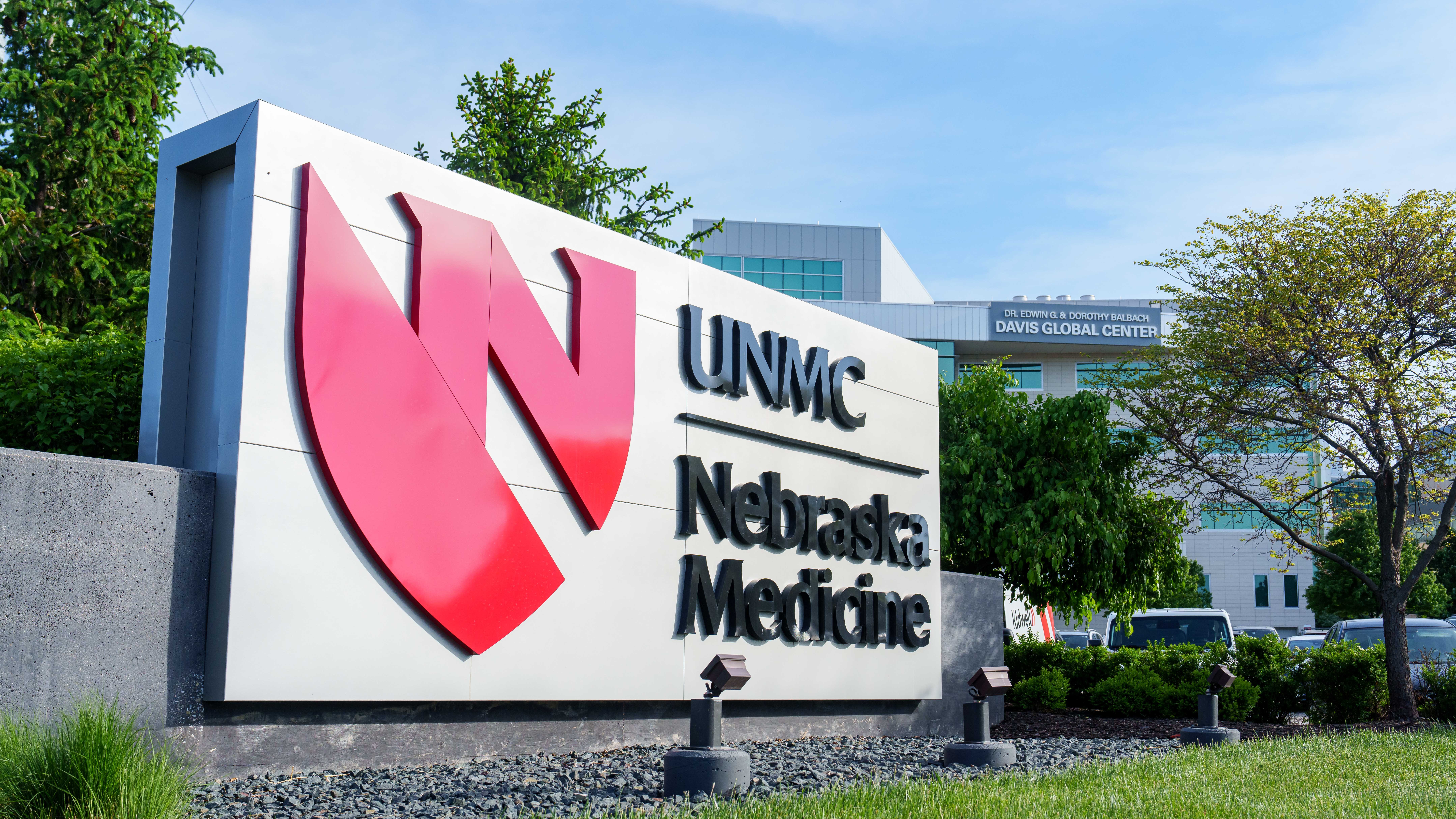 A Nebraska Medicine sign stands in front of a green lawn.