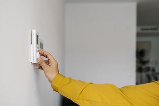 Woman operating a thermostat