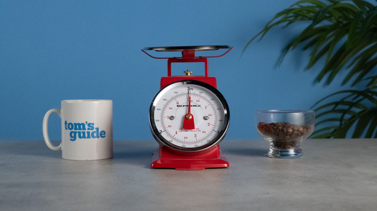 A set of red scales with a mug on the left and a glass of coffee beans on the right. Taken at ISO6400 on the Nikon Z50II.