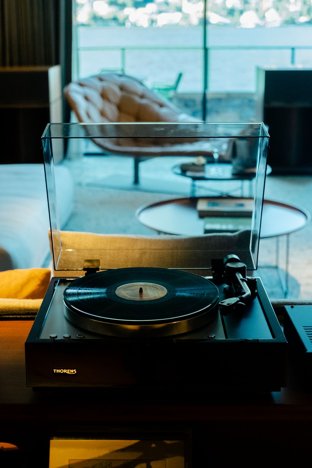 A high-fidelity suite fitted with retro-inspired amplifiers, speakers, a turntable, and a sprawling record collection features a mid-century-cool vibe through wood-clad surfaces and sculptural designs.