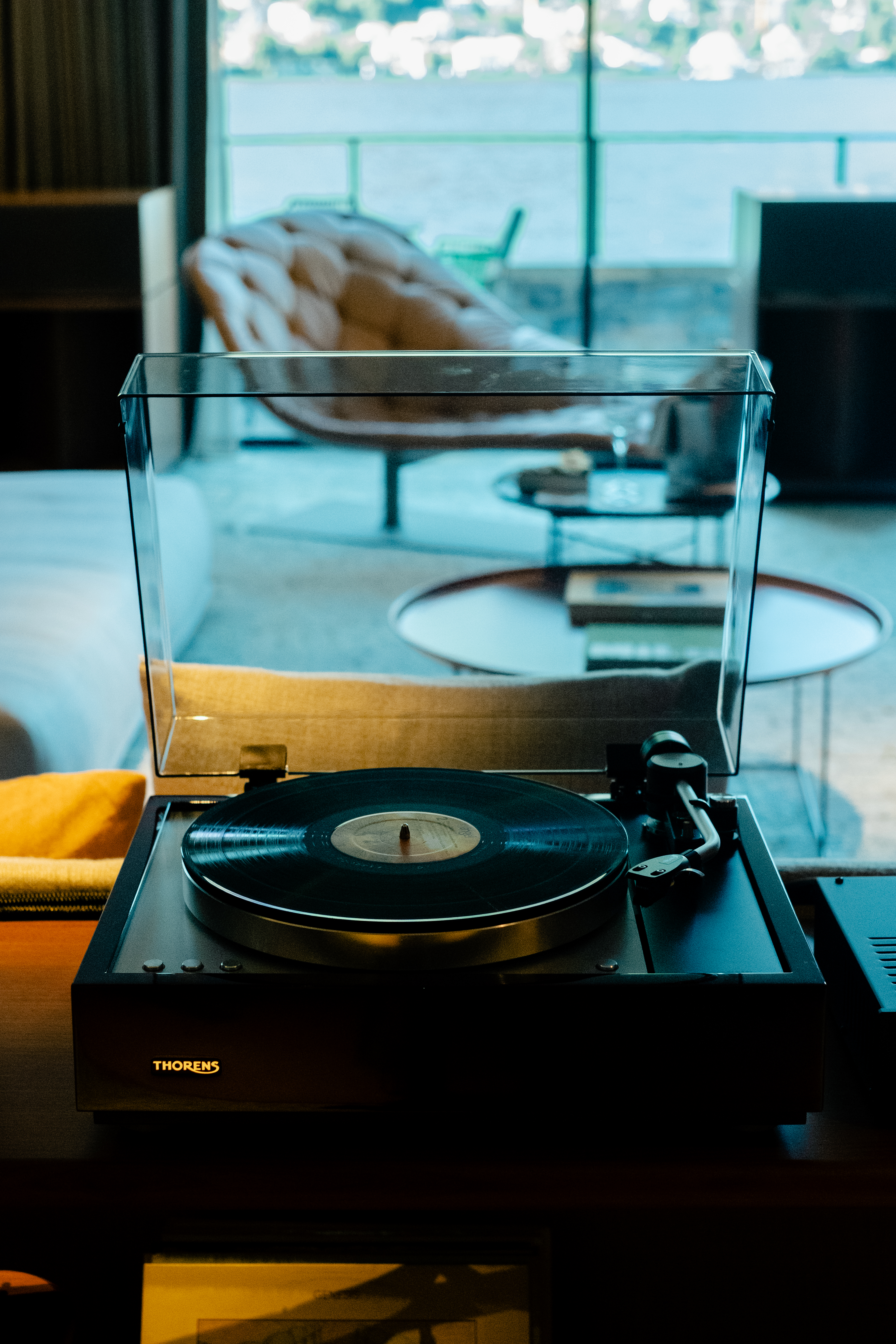 A high-fidelity suite fitted with retro-inspired amplifiers, speakers, a turntable, and a sprawling record collection features a mid-century-cool vibe through wood-clad surfaces and sculptural designs.