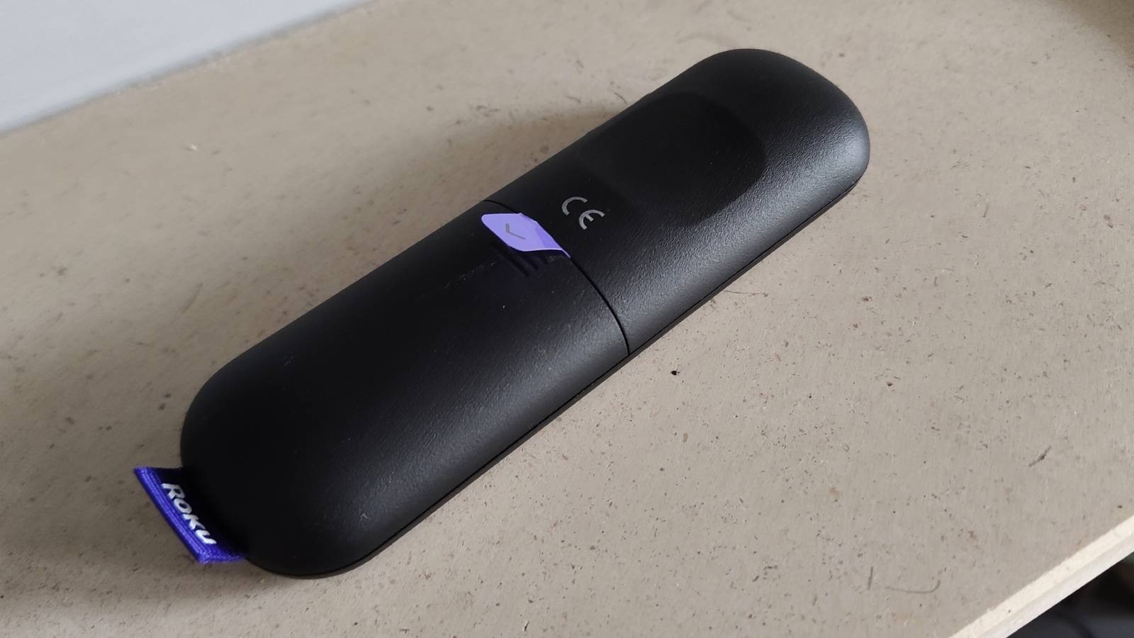 The Roku Streaming Stick's remote flipped over with a plastic tab sticking out of it.
