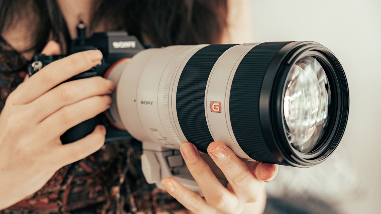 Sony FE 70-200mm f/2.8 GM OSS II Lens being held by the reviewer