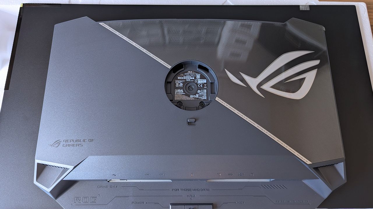 Back of the ASUS ROG Strix OLED monitor showing the ROG logo, mounting area, and labeled HDMI, DP, USB, and power ports.