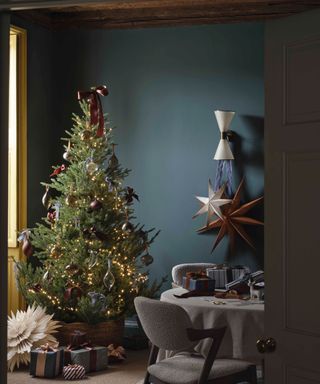 dark blue living room with Christmas tree with muted red decorations