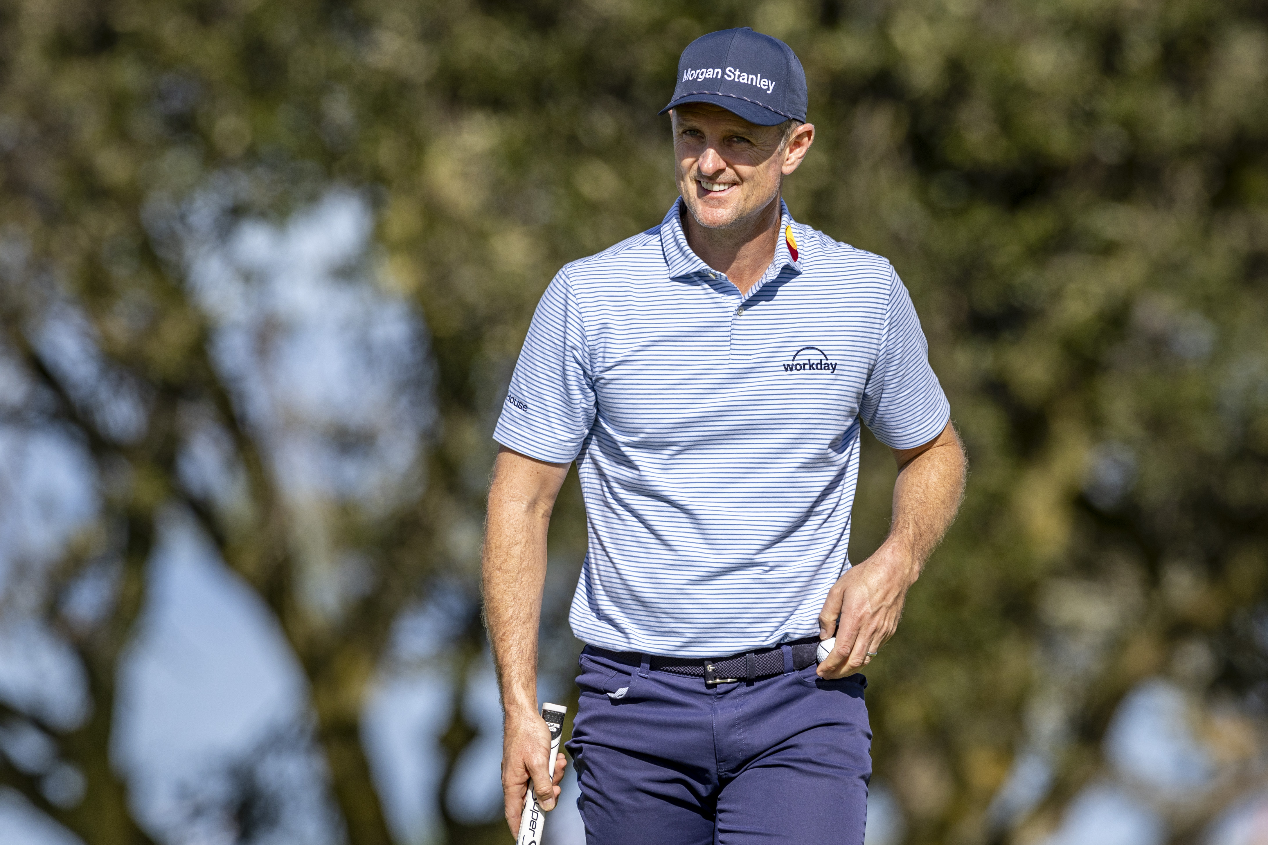 Justin Rose smiles as he walks off the green