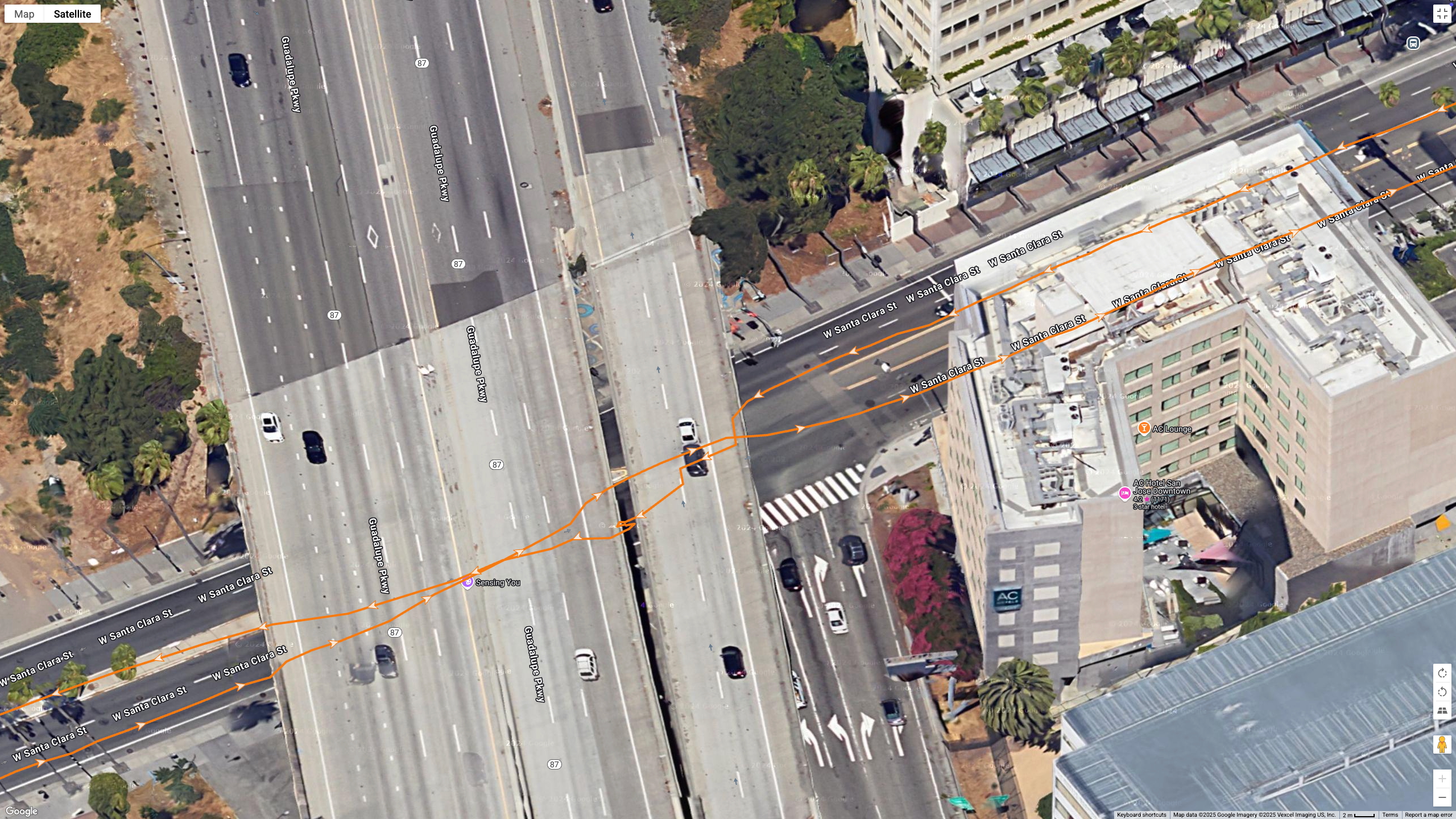 Google Maps satellite data showing how the Garmin Forerunner 970 (orange line) tracks my position during a race in downtown San Jose under an underpass and near tall buildings.