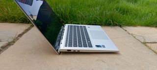 A silver MSI Prestige 14 Evo B13M laptop sitting on a patio rock