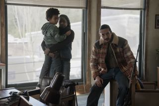 rutina wesley and gabriel luna in the last of us season 2 looking concerned while standing inside a cabin