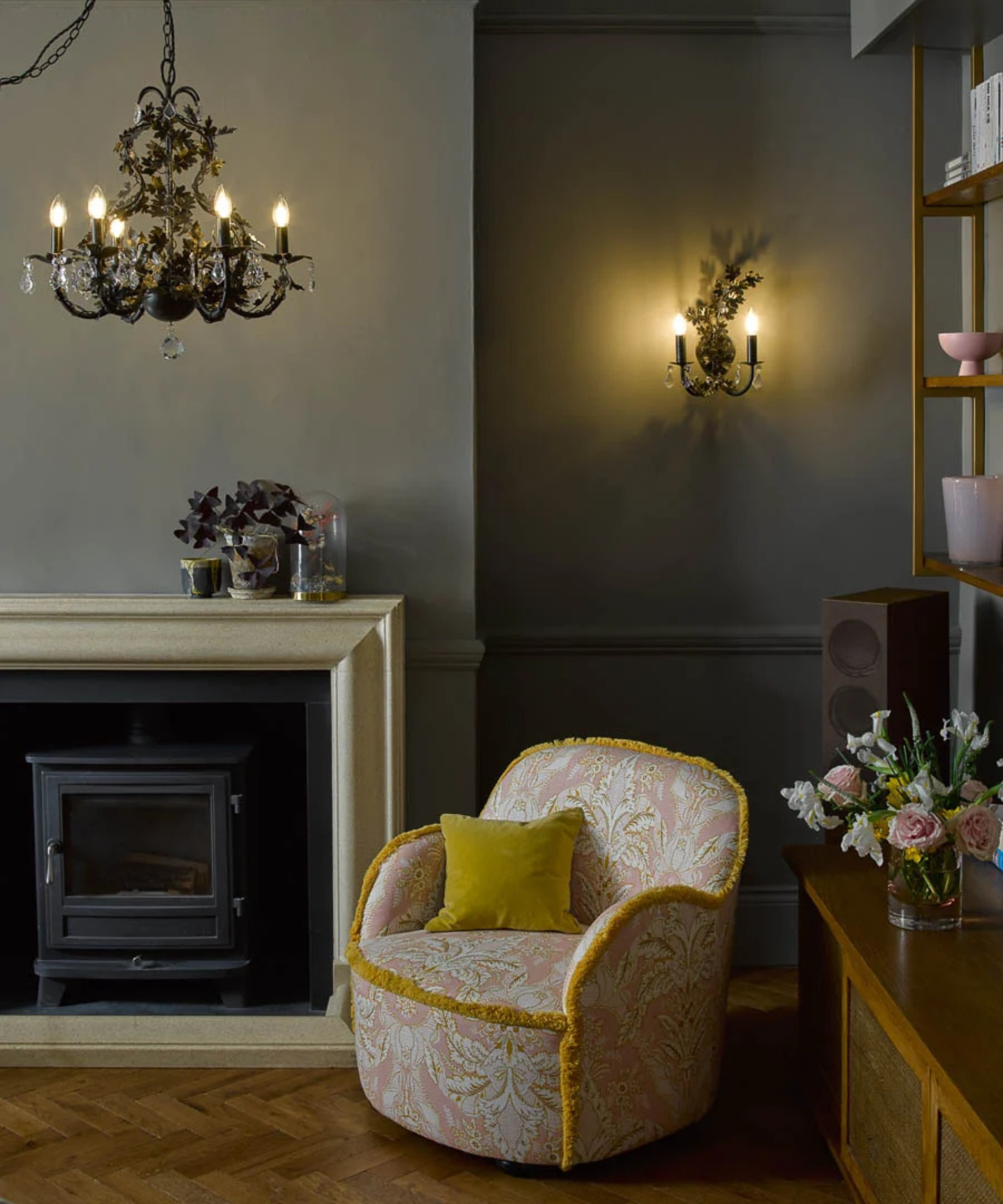 Corner of living room with chandelier, wall light and small armchair