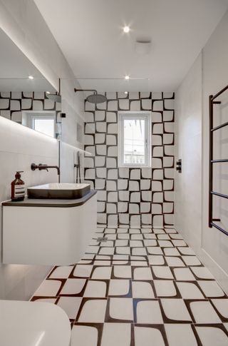 narrow wet room with black and white patterned tiles