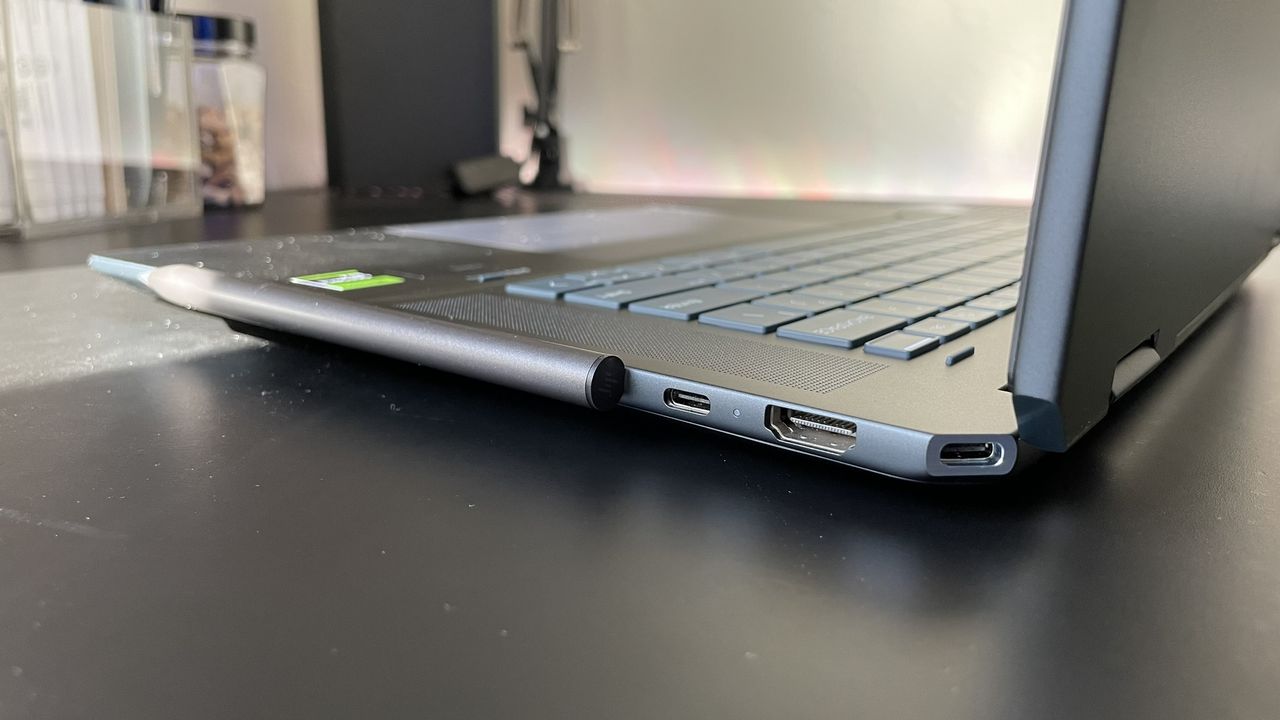 A close up of connectivity ports on the side of a laptop on top of a black surface.