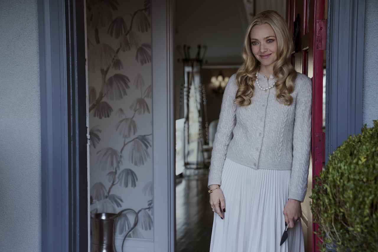 Amanda Seyfried smiling in a doorway in The Housemaid