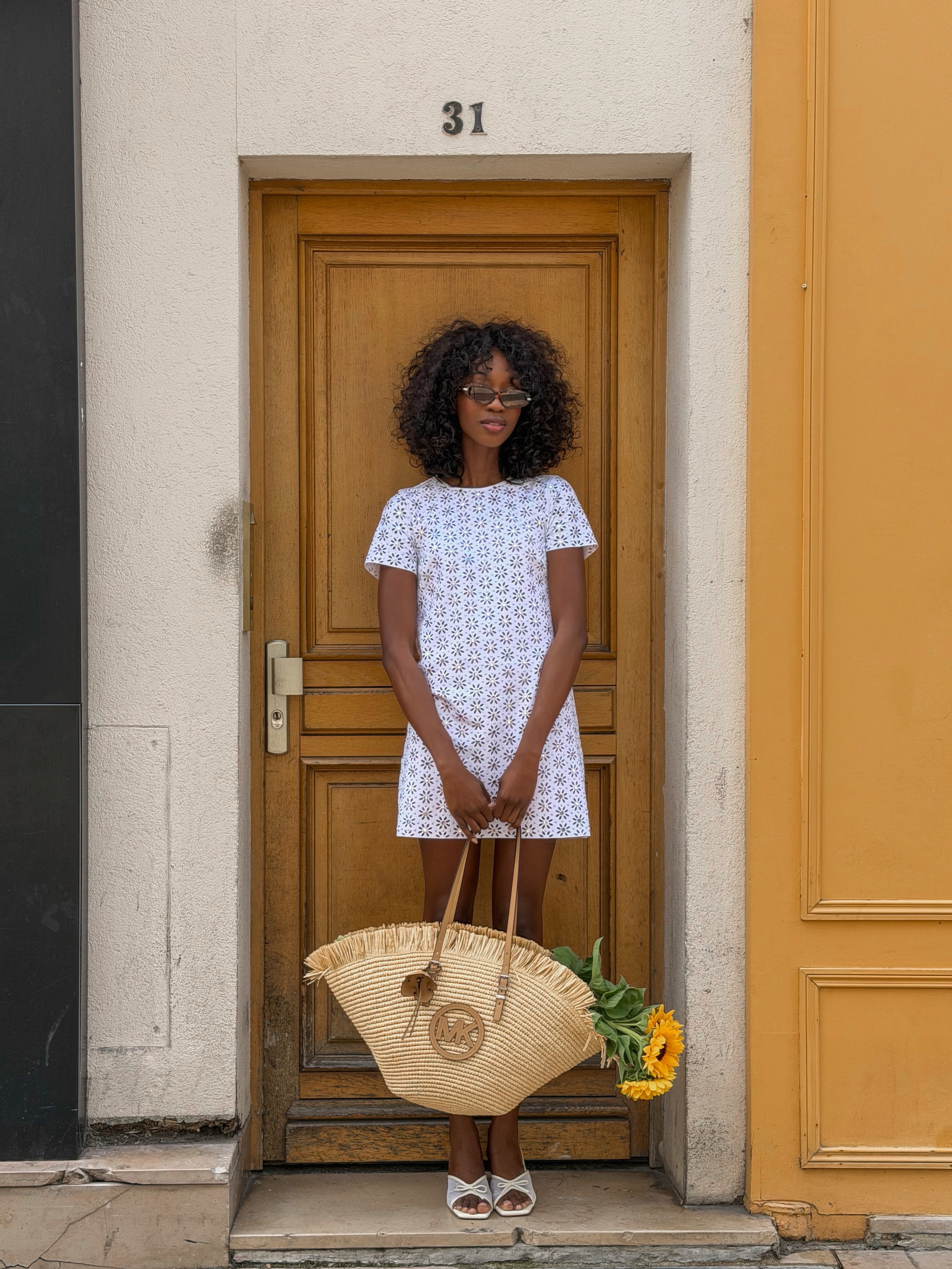 Emmanuelle Koffi with a straw tote.
