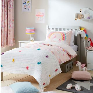 kids room with white wall wooden floor bed lamp and toys