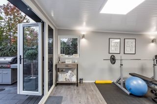 garden room that's a home gym with gym equipment and gym prints on the wall