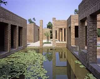 The pavilions are made out of red brick, with a pool in between them.