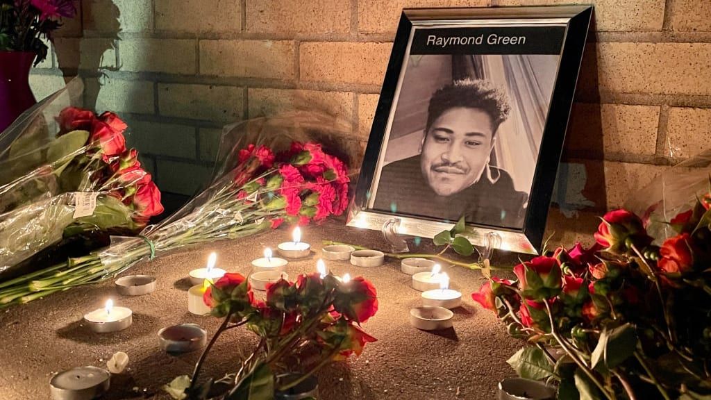 Flowers in front of a picture of shooting victim Raymond Vance.