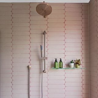 bathroom with shower with rose gold brasswarea glass shelf for shampoo bottles and pink tiles