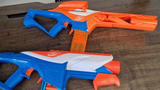 Two Nerf N-Series blasters on a wooden surface