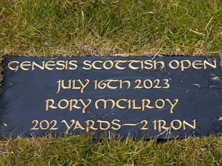 A plaque signifying Rory McIlroy's 202 yard 2-iron shot at the 2023 Scottish Open