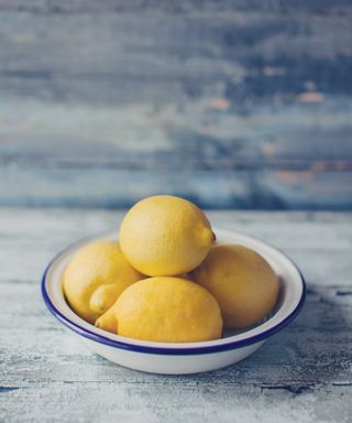 Lemons in a bowl on a wooden table