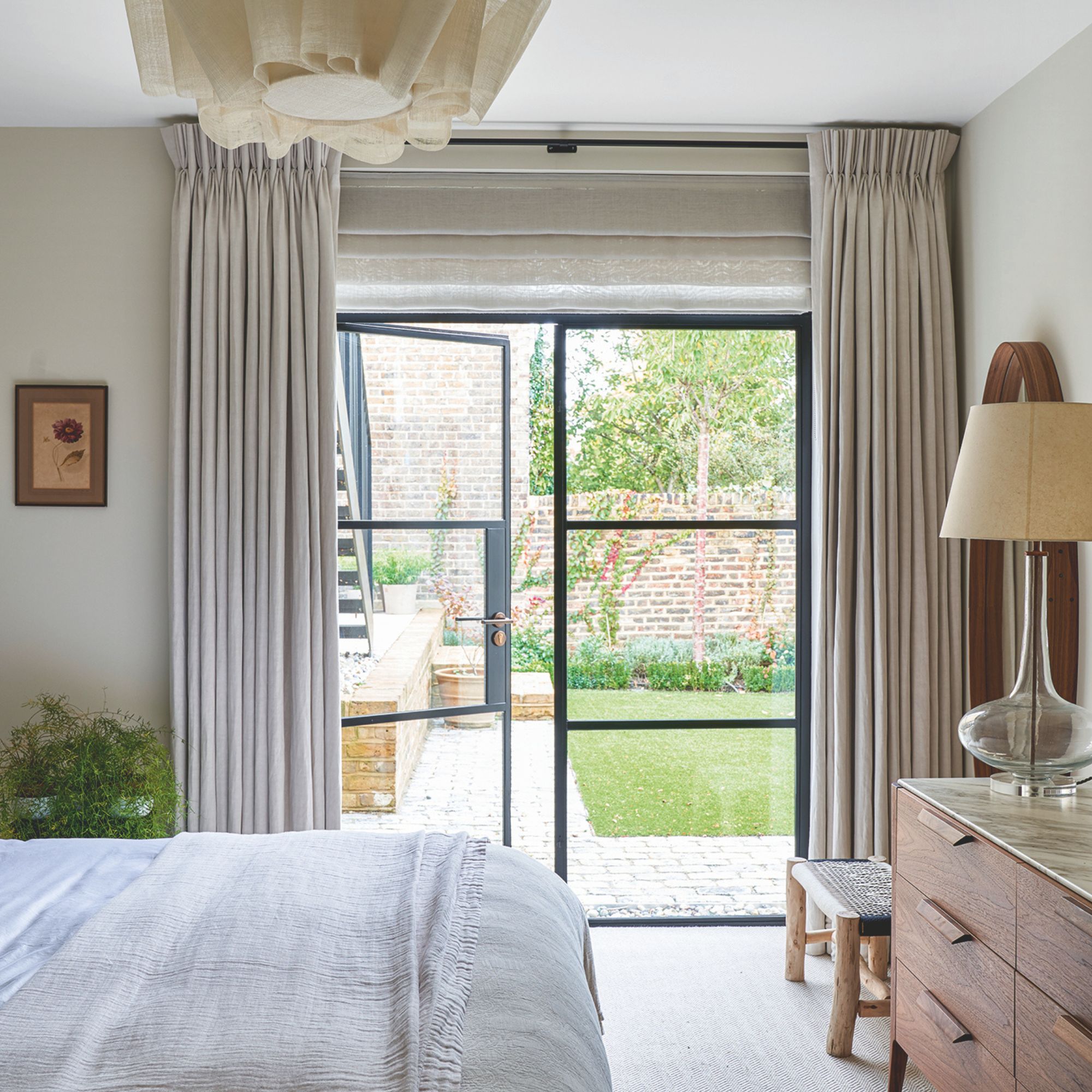 Neutral ground floor bedroom with crittal doors leading to the garden