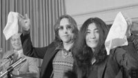 John Lennon and Yoko Ono waving white flags at the press conference to launch Nutopia in 1973