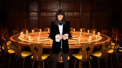 Claudia Winkleman in front of The Traitors round table 