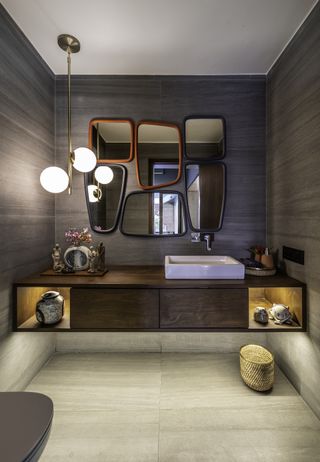 A small bathroom with multiple mirrors in colorful frames