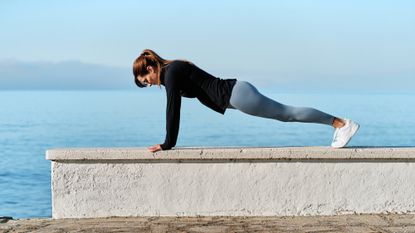 A woman performing a push-up outdoors