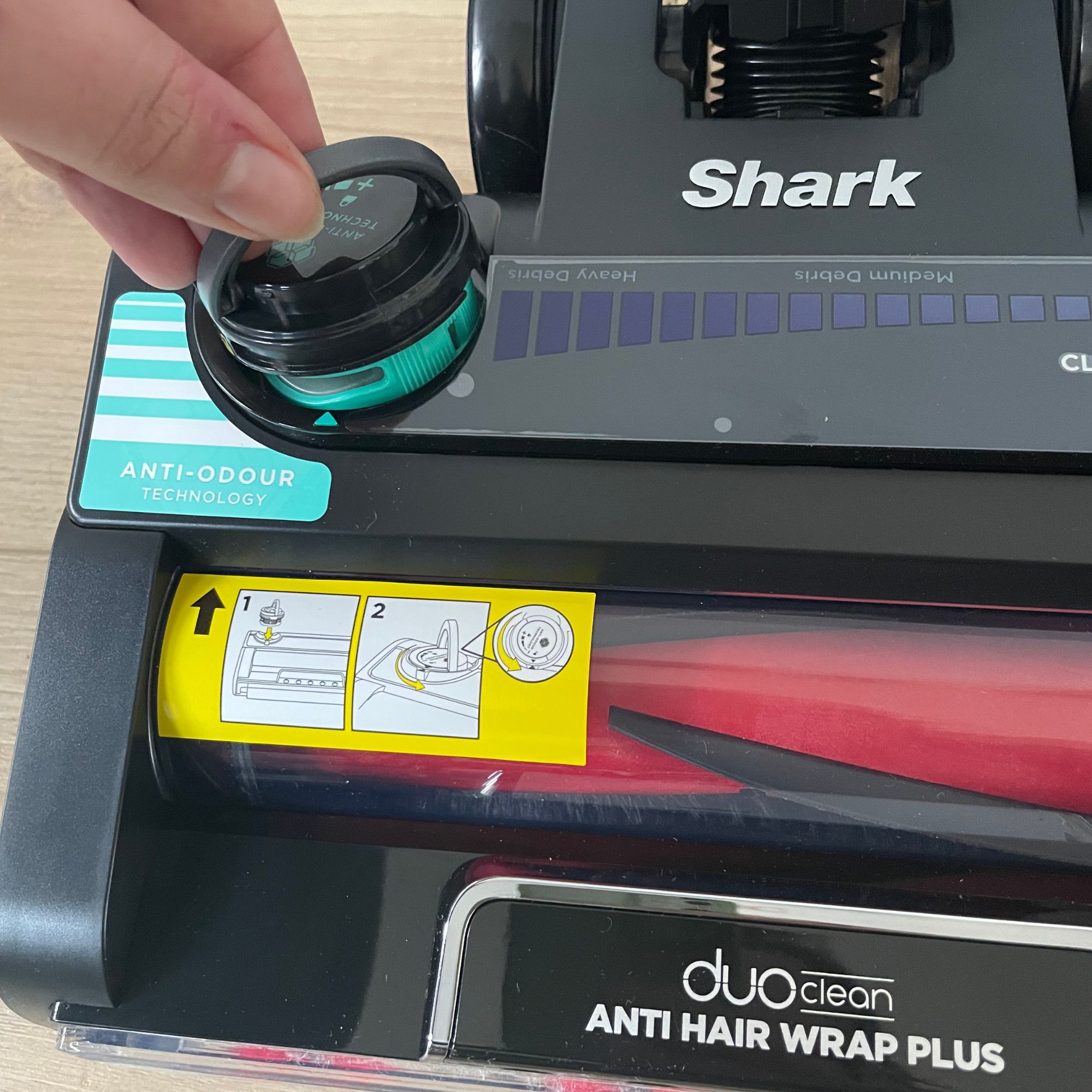 Hand inserting an anti-odour cartridge into the floorhead of the Shark Stratos Cordless Vacuum