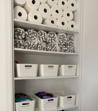 Organized toilet paper and linens in closet space