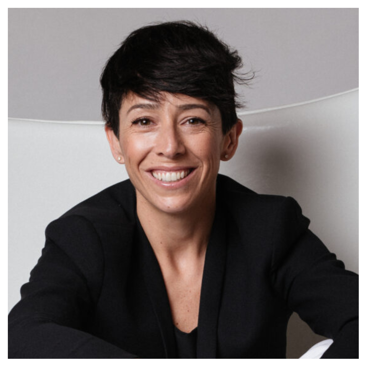 A headshot of Gala Magriñá sitting in a white chair