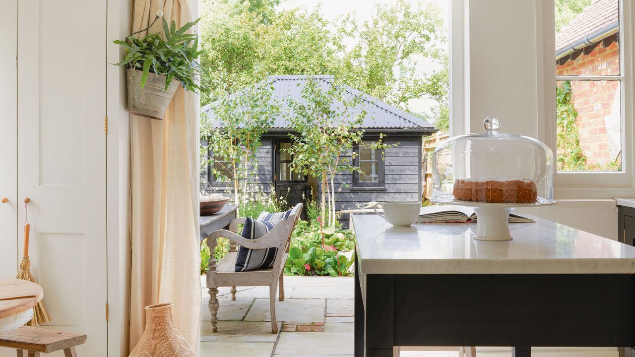 country kitchen with farmhouse-style island and view to garden through french doors