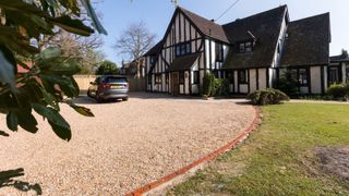 mock Tudor house with buff coloured gravel driveway