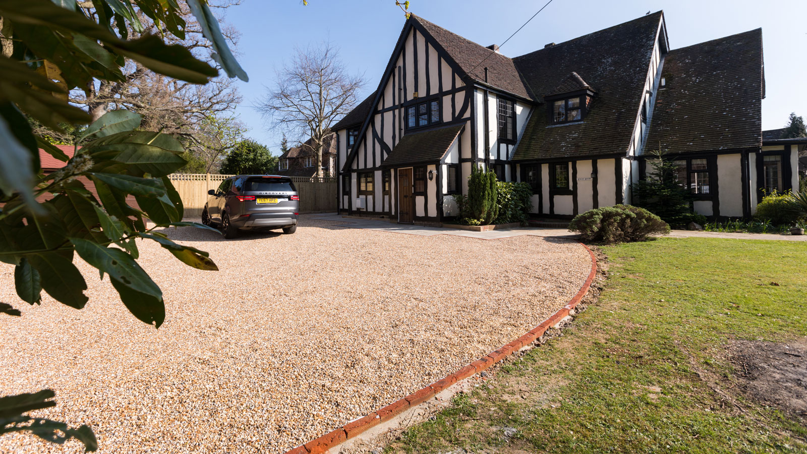 mock Tudor house with buff coloured gravel driveway