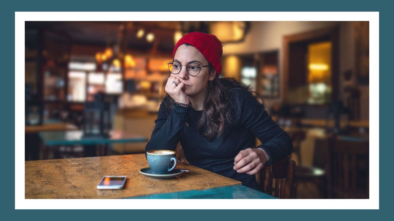 Girl alone at a coffee shop looking frustrated, as if she&#039;s just been stood up