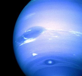 This image of Neptune was captured by NASA's Voyager 2 spacecraft during an August 1989. Neptune's Great Dark Spot dominates the center along with bright, white. To the south is the bright feature nicknamed "Scooter." Still farther south is the "Dark Spot 2," which has a bright core. Each feature moves eastward at a different velocity, so it is only occasionally that they appear close to each other as shown here