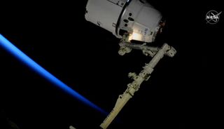 The last SpaceX Dragon to be captured by a robotic arm on the International Space Station is seen just after capture on March 9, 2020. All future Dragons will be able to dock themselves at the station.