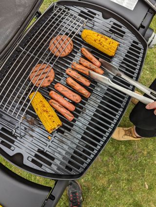 corn, sausages and burgers cooking on he weber q 3200